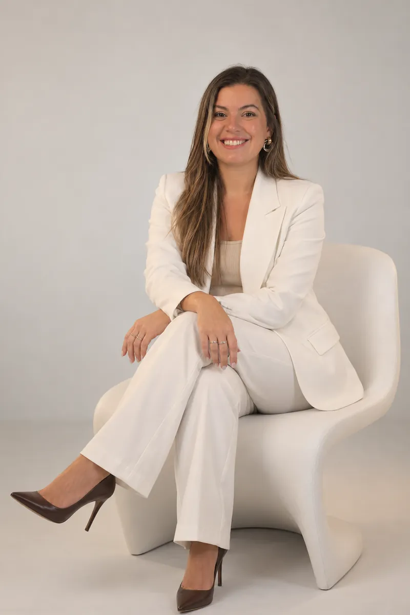 Micaela Belén Rossi, sentada, con traje blanco