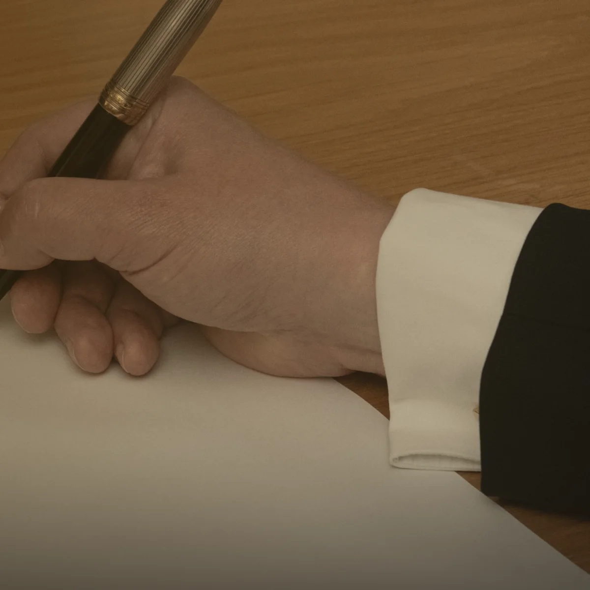 Una mano firma un contrato con pluma estilográfica