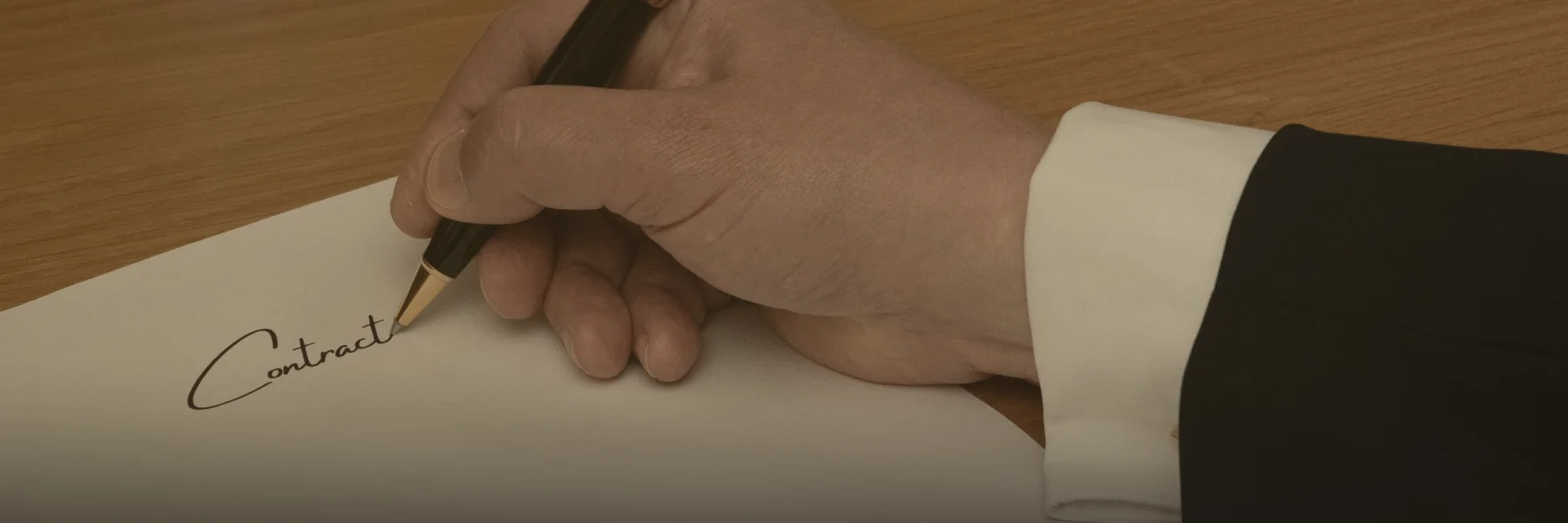 Una mano firma un contrato con pluma estilográfica