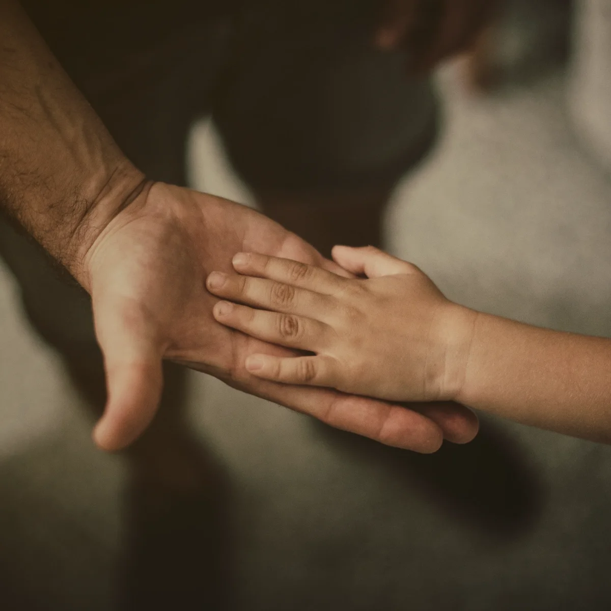La mano de un niño sobre la palma de un adulto