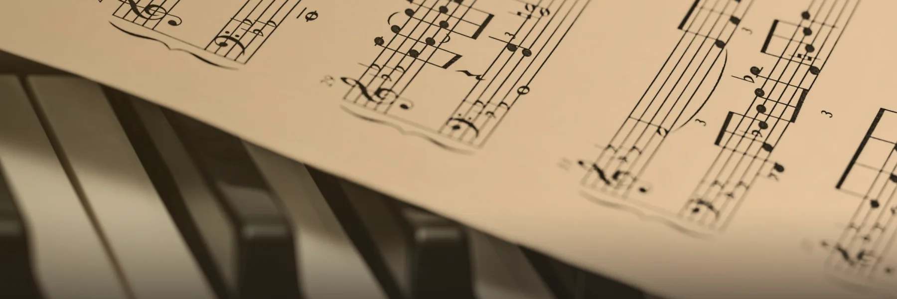 Una partitura apoyada sobre las teclas de un piano